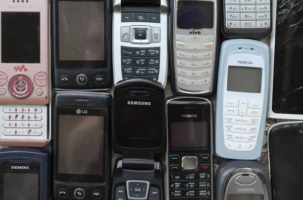 Niektóre stare używane przestarzałe telefony komórkowe. Recykling elektroniki na rynku Tanie — Zdjęcie stockowe