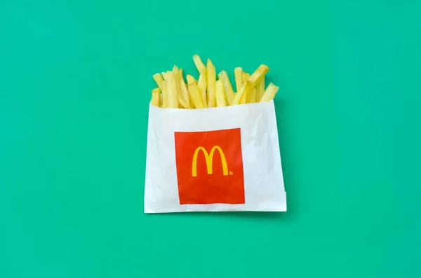 McDonald's French fries in small paperbag on bright green background — Stock Image McDonald's French fries in small paperbag on bright green background Royalty Free Stock Photos