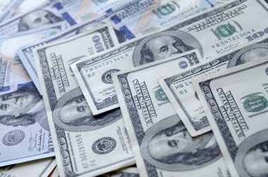 Soyut desenli arka plan ve yüzlerce dolarlık banknotlar.