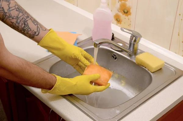 Person or householder cleaning the kitchen sink with sponge in close up view — Stock Photo, Image