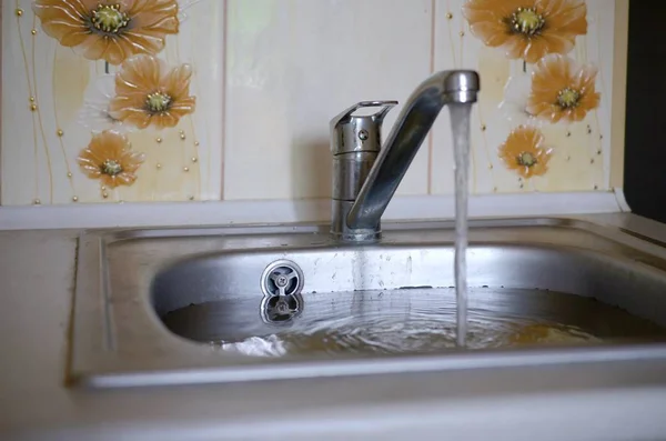 Foro tappo lavello in acciaio inox vicino pieno di acqua e particelle di cibo — Foto Stock