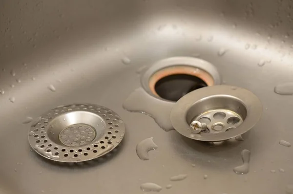 Silvery kitchen sink with a disassembled protective filter during the repair process — Stock Photo, Image