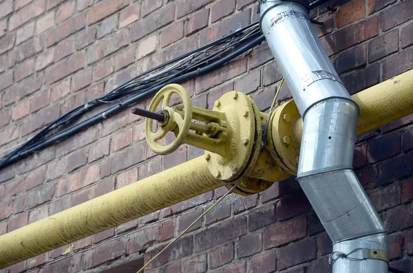 Velha válvula de controle de gás amarelo enferrujado na parede de tijolo — Fotografia de Stock