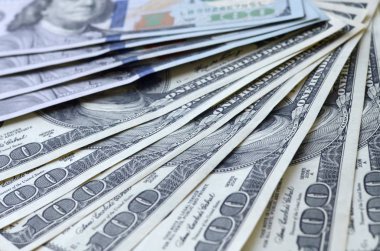 Soyut desenli arka plan ve yüzlerce dolarlık banknotlar.