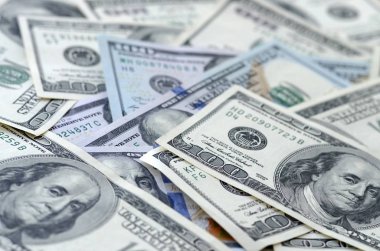 Soyut desenli arka plan ve yüzlerce dolarlık banknotlar.