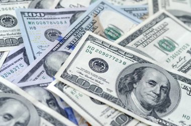 Soyut desenli arka plan ve yüzlerce dolarlık banknotlar.