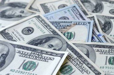 Soyut desenli arka plan ve yüzlerce dolarlık banknotlar.