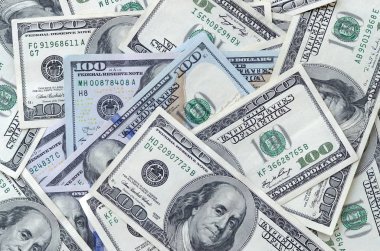 Soyut desenli arka plan ve yüzlerce dolarlık banknotlar.