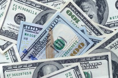Soyut desenli arka plan ve yüzlerce dolarlık banknotlar.