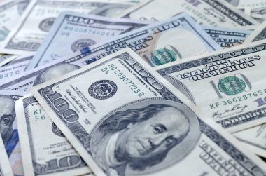 Soyut desenli arka plan ve yüzlerce dolarlık banknotlar.