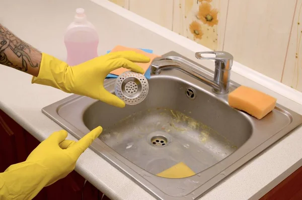 Nettoyant dans des gants en caoutchouc montre protecteur plughole propre d'un évier de cuisine — Photo
