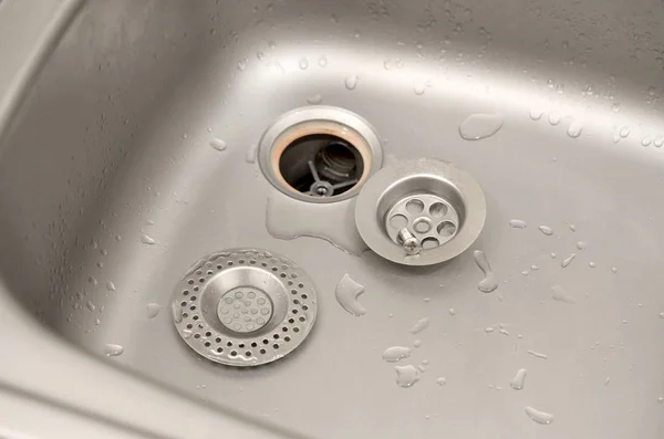 Silvery kitchen sink with a disassembled protective filter during the repair process — Stock Photo, Image