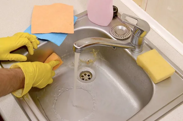 Человек или домовладелец чистят кухонную раковину губкой в поле зрения — стоковое фото