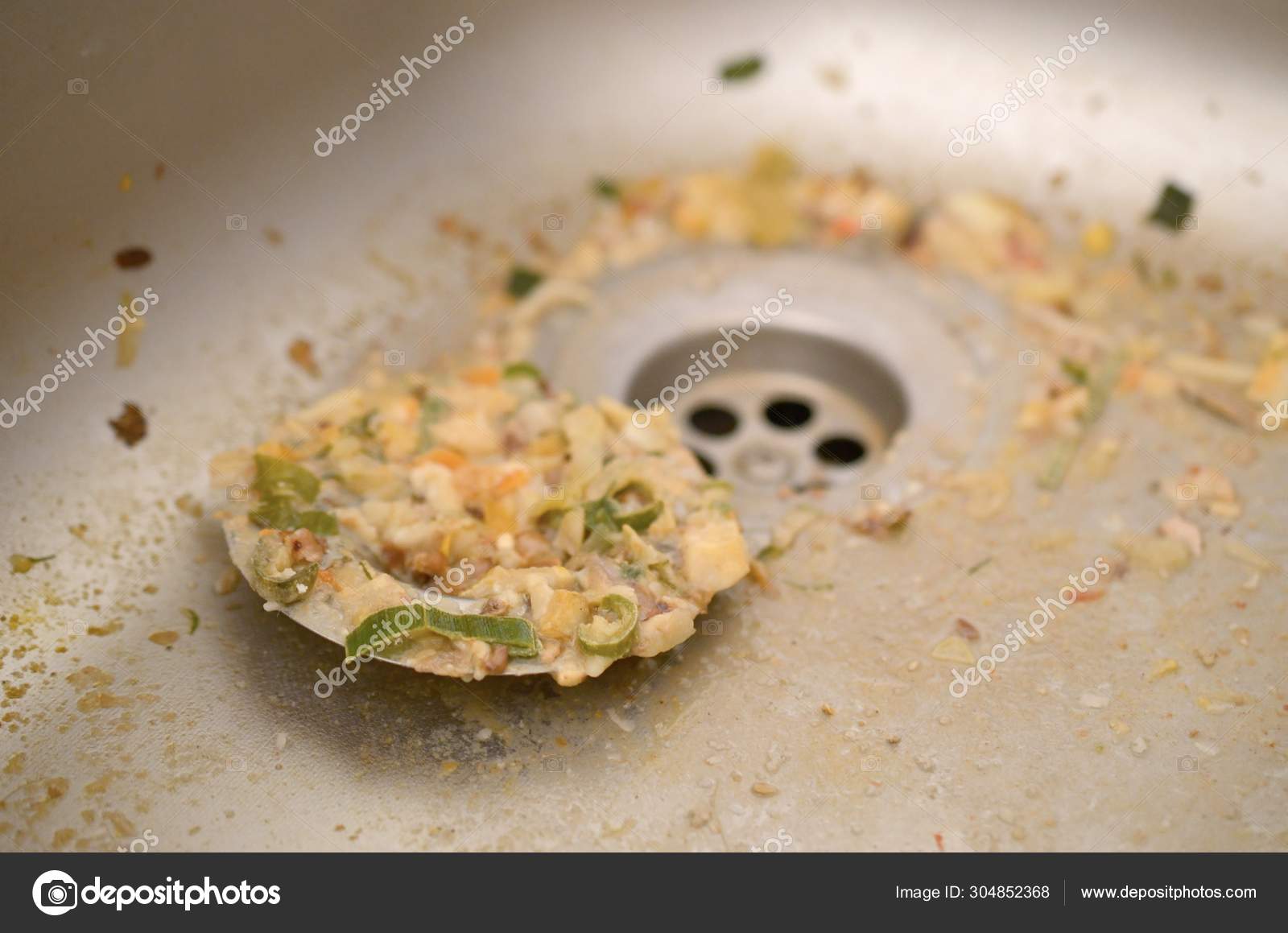 Close up on dirty clogging kitchen sink drain with food particles