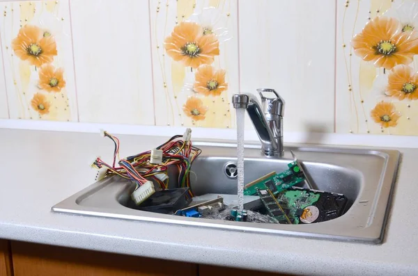Hardware en fregadero de cocina bajo el flujo de agua ordenador limpieza concepto metafórico — Foto de Stock