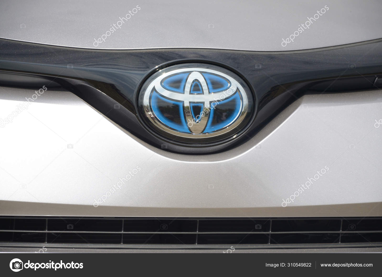 丰田银质汽车前部的标志在室外关门—— 库存社论照片© Mehaniq #310549822