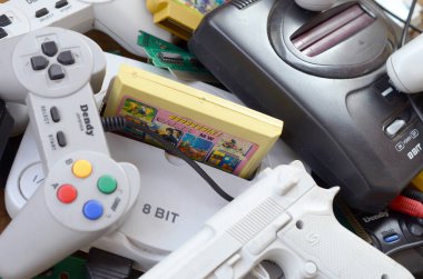 Eski 8-bit video oyun konsolları ve joystickler ve kartuşlar gibi birçok oyun aksesuarı yığını