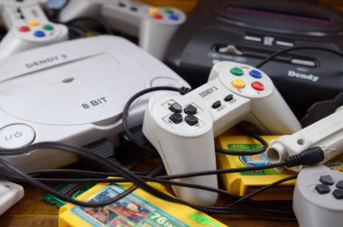 Eski 8-bit video oyun konsolları ve joystickler ve kartuşlar gibi birçok oyun aksesuarı yığını