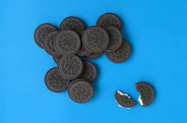 Mavi arka planda birçok Oreo sandviç kremalı bisküvi.