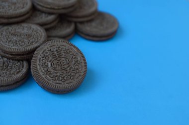Mavi arka planda birçok Oreo sandviç kremalı bisküvi.