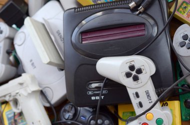 Eski 8-bit video oyun konsolları ve joystickler ve kartuşlar gibi birçok oyun aksesuarı yığını