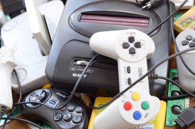 Eski 8-bit video oyun konsolları ve joystickler ve kartuşlar gibi birçok oyun aksesuarı yığını