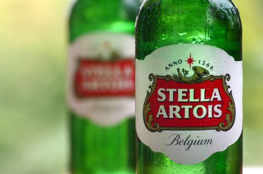 Bulanık yeşil ağaçlarda Stella Artois birası şişeleri