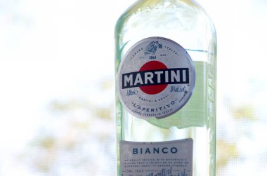 Bir şişe Vermouth Martini Rossi. Yeşil ağaçların arkasındaki logoyu kapat.