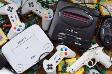 Eski 8-bit video oyun konsolları ve joystickler ve kartuşlar gibi birçok oyun aksesuarı yığını
