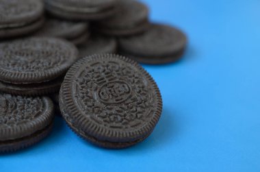 Mavi arka planda birçok Oreo sandviç kremalı bisküvi.