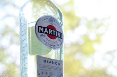 Bir şişe Vermouth Martini Rossi. Yeşil ağaçların arkasındaki logoyu kapat.