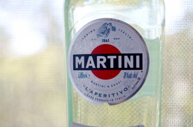 Bir şişe Vermouth Martini Rossi. Yeşil ağaçların arkasındaki logoyu kapat.