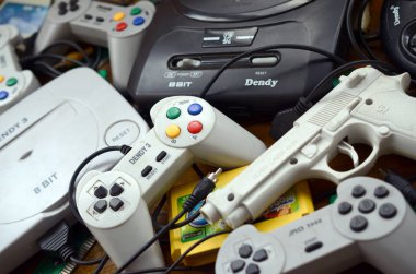 Eski 8-bit video oyun konsolları ve joystickler ve kartuşlar gibi birçok oyun aksesuarı yığını