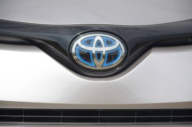Gümüş renkli arabada Toyota logosu. Ön taraf açık havada.
