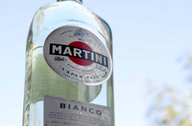 Bir şişe Vermouth Martini Rossi. Yeşil ağaçların arkasındaki logoyu kapat.