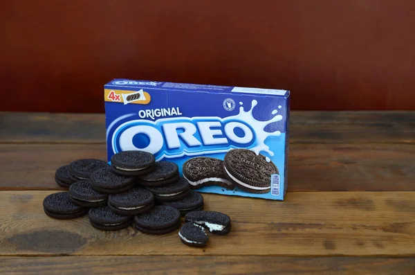 Muitos biscoitos de creme de sanduíche OREO com pacote em fundo de madeira — Fotografia de Stock