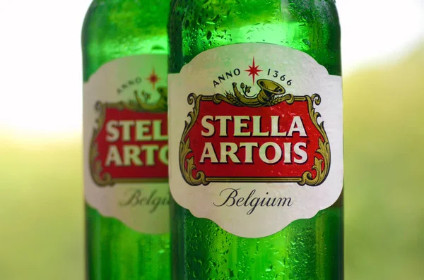 Bulanık yeşil ağaçlarda Stella Artois birası şişeleri — Stok fotoğraf