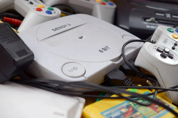 Pile of old 8-bit video game consoles and many gaming accessories like a joysticks and cartridges — Stock Photo, Image