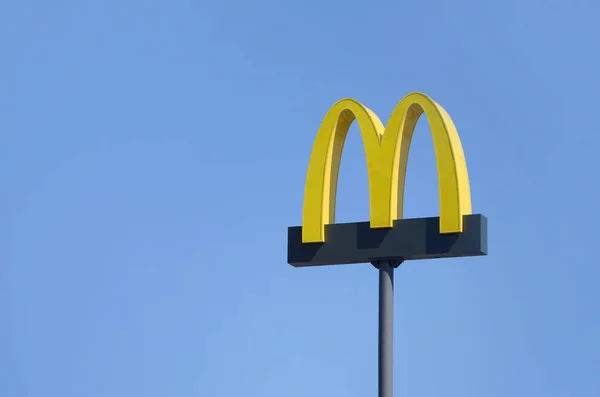 Mcdonalds gelb großes logo auf blauem himmel hintergrund — Stockfoto