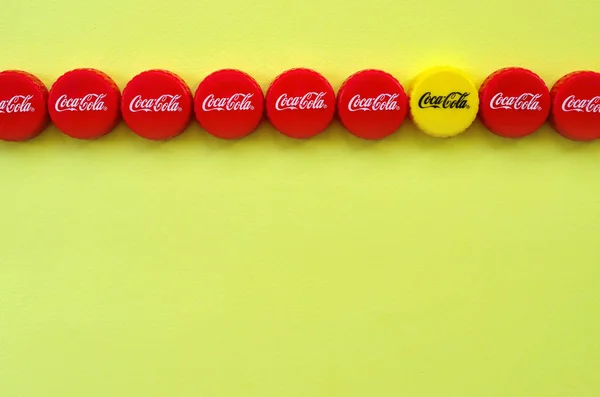 Banyak topi merah dengan logo coca cola pada latar belakang kuning — Stok Foto