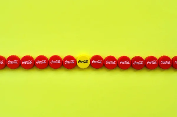 Banyak topi merah dengan logo coca cola pada latar belakang kuning — Stok Foto