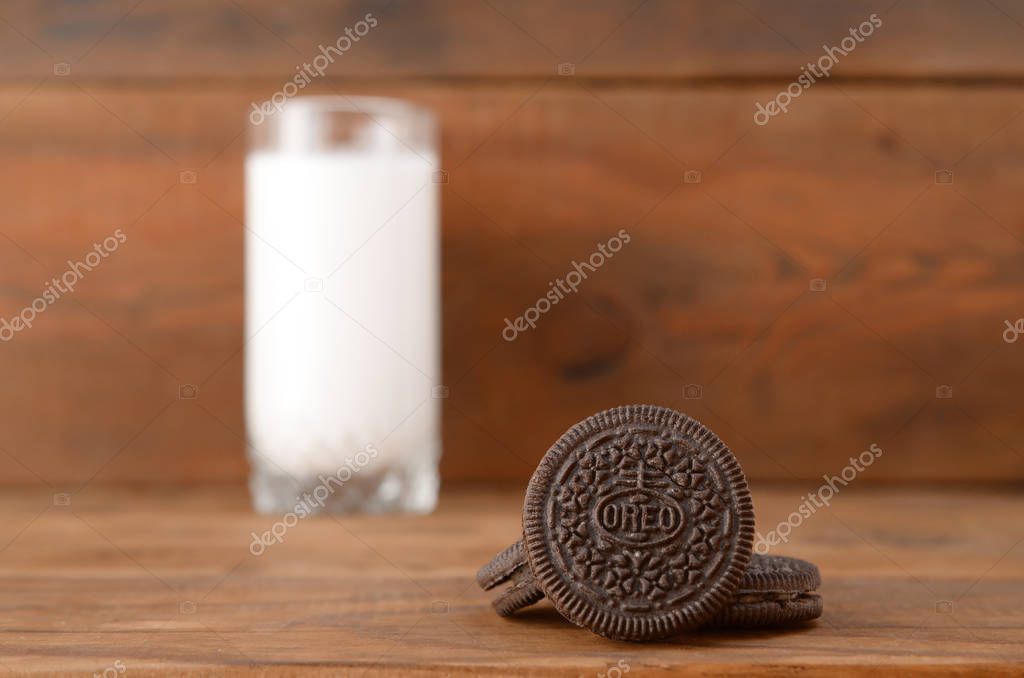 KHARKOV, UKRAINE - SEPTEMBER 8, 2019: Many OREO sandwich cream biscuits and milk glass on wooden background. Oreo is a sandwich cookie with a sweet cream is the best selling cookie in the US