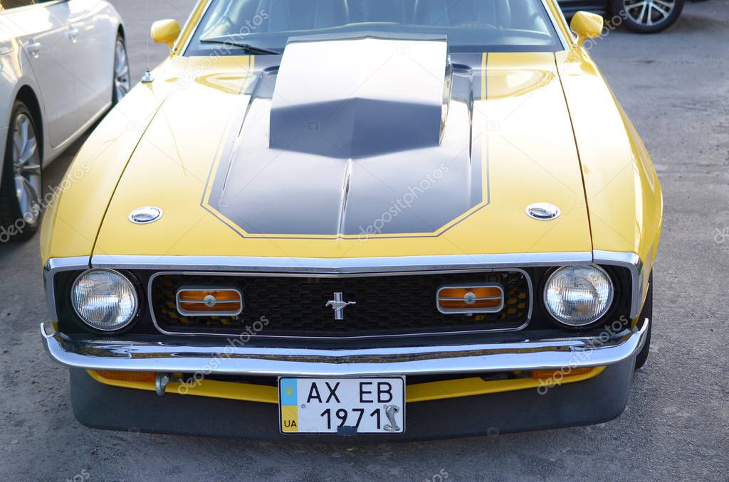 KHARKOV, UKRAINE - SEPTEMBER 24, 2019: Front view of Ford Mustang Mach 1 in bright yellow color on public parking place
