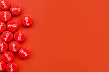 Kırmızı arkaplanda Coca Cola logosu olan birçok kırmızı başlık