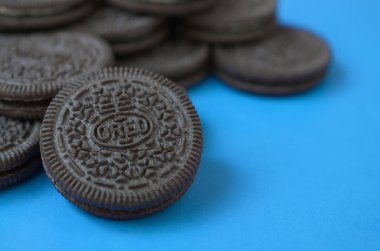 Mavi arka planda birçok Oreo sandviç kremalı bisküvi.