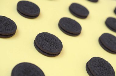 Sarı arka planda birçok Oreo sandviç kremalı bisküvi.