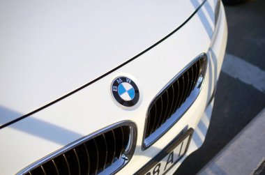 Şirketin logosuna sahip beyaz Bmw arabasının ön görüntüsü