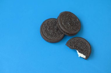Mavi arka planda birçok Oreo sandviç kremalı bisküvi.