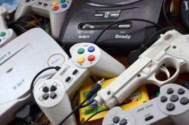 Eski 8-bit video oyun konsolları ve joystickler ve kartuşlar gibi birçok oyun aksesuarı yığını