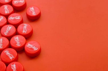 Kırmızı arkaplanda Coca Cola logosu olan birçok kırmızı başlık